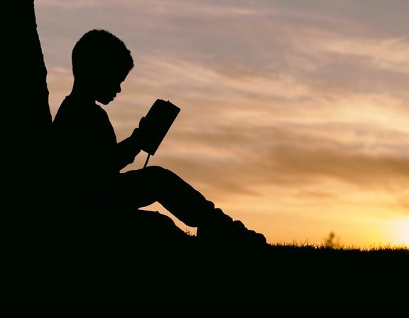 Large canva   silhouette of a kid reading at sunset